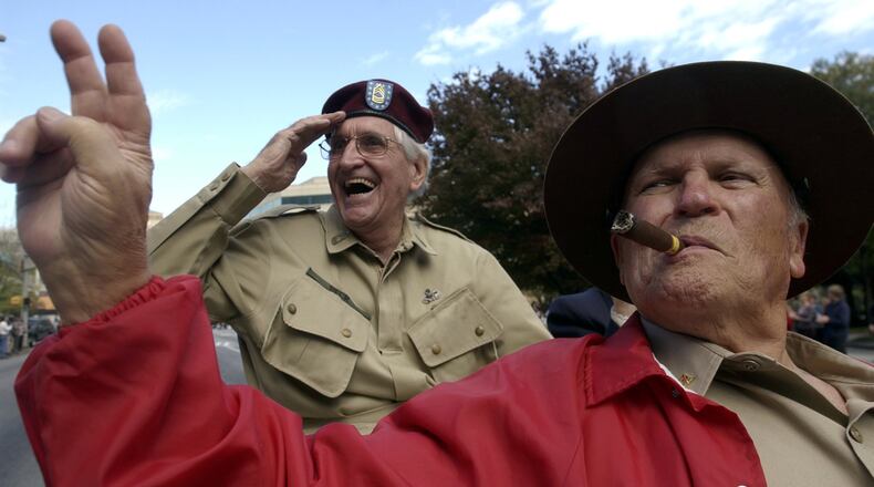 Master Sgt. Carl Beck (left) and Cpl. Cal Stephenson, who both served in World War II and now both deceased, pass the judges stand during the Georgia Veterans Day Parade in Midtown Atlanta. The two were representing the Atlanta World War II Roundtable. (BEN GRAY/STAFF)