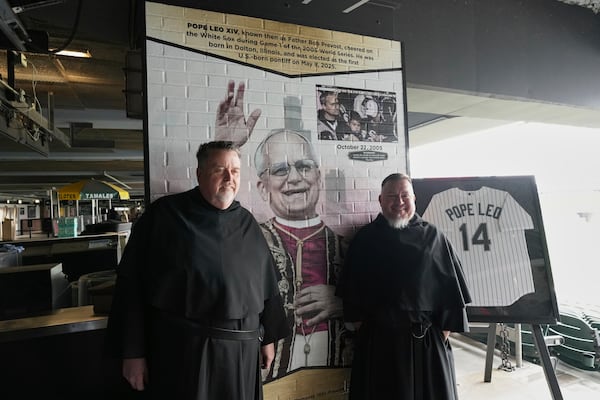 Father Tom McCarthy, left, and Brother Joe Ruiz, right, pose for a photo after a news conference for the Chicago White Sox's commemoration of team fan Pope Leo XIV with a graphic installation at Rate Field before a baseball game between the Seattle Mariners and the White Sox in Chicago, Monday, May 19, 2025. (AP Photo/Nam Y. Huh)