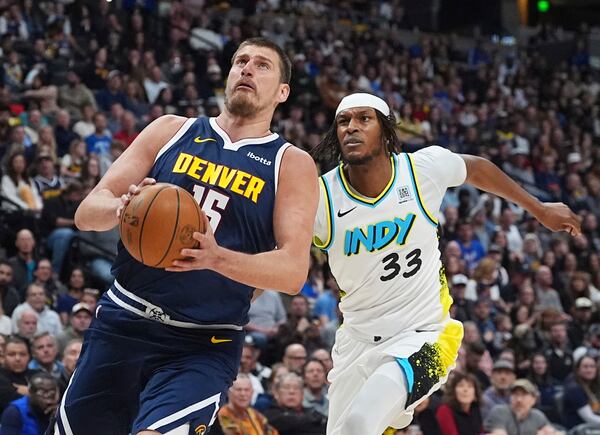Denver Nuggets center Nikola Jokic, front, drives to the basket past Indiana Pacers center Myles Turner in the first half of an NBA basketball game Sunday, April 6, 2025, in Denver. (AP Photo/David Zalubowski)