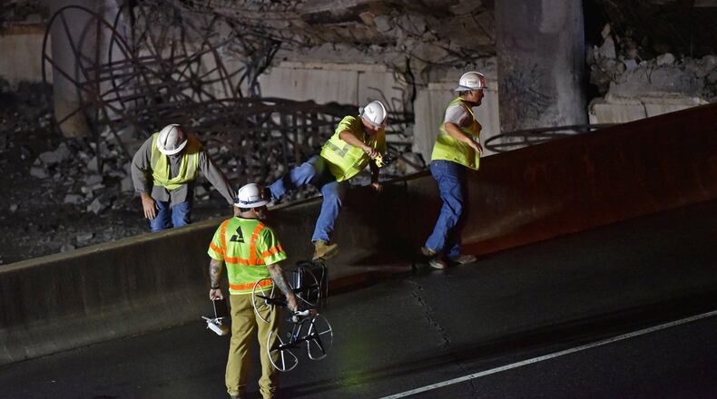 March 30, 2017 Atlanta - Crew surveys the section of an overpass that collapsed from a fire on I-85 on Thursday, March 30, 2017. Fire officials extinguished a massive fire on I-85 on Thursday night after it burned for more than an hour and led to the collapse of a bridge on the interstate, fire officials said. HYOSUB SHIN / HSHIN@AJC.COM