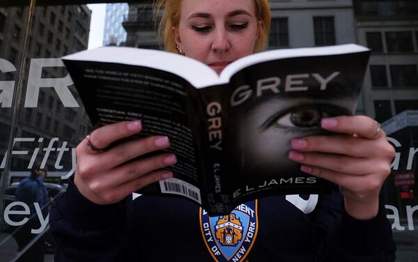 A woman reads a copy of E.L James's book "Grey: Fifty Shades of Grey as Told by Christian" as she waits in a line to get the book signed by the author at the Barnes and Noble store on Fifth Avenue in New York on June 18, 2015.  "Fifty Shades" trilogy is a record-breaking contemporary publishing phenomenon, selling more than 125 million copies worldwide and translated into more than 50 languages. (JEWEL SAMAD/AFP/Getty Images)