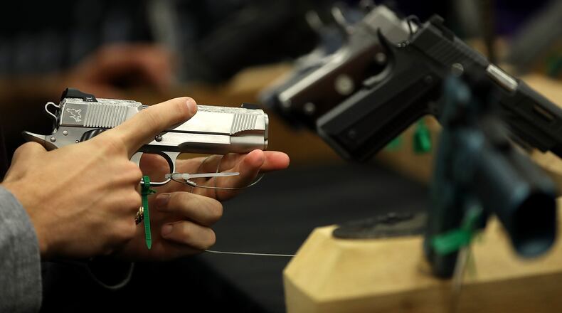 An attendee inspects a handgun during the NRA annual meeting in Dallas, Texas, last week. Justin Sullivan/Getty Images