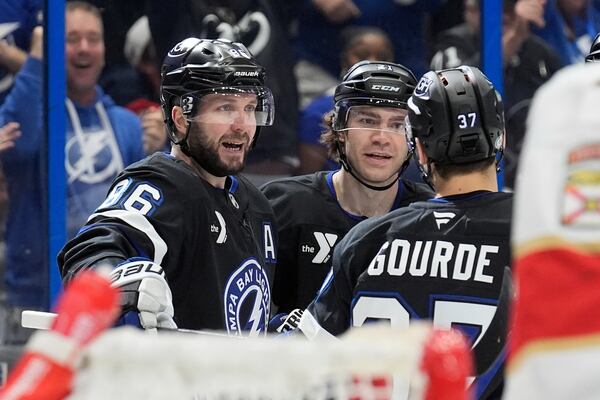 Tampa Bay Lightning right wing Nikita Kucherov (86) celebrates his goal against the Florida Panthers with center Brayden Point (21) and center Yanni Gourde (37) during the second period of an NHL hockey game Tuesday, April 15, 2025, in Tampa, Fla. (AP Photo/Chris O'Meara)