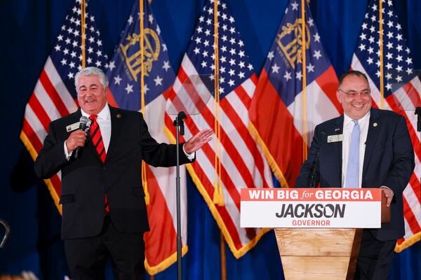 State Rep. Lauren McDonald III (left) takes the stage with state Rep. Brent Cox, at Rick Jackson's election night watch party in June. (Jason Getz/AJC)