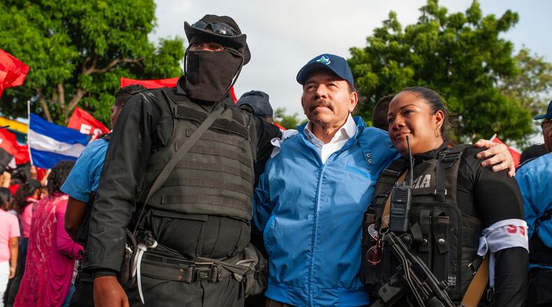 FILE - Nicaraguan police have their picture taken with President Daniel Ortega, in Masaya, Nicaragua, July 13, 2018. (AP Photo/Cristobal Venegas, File)