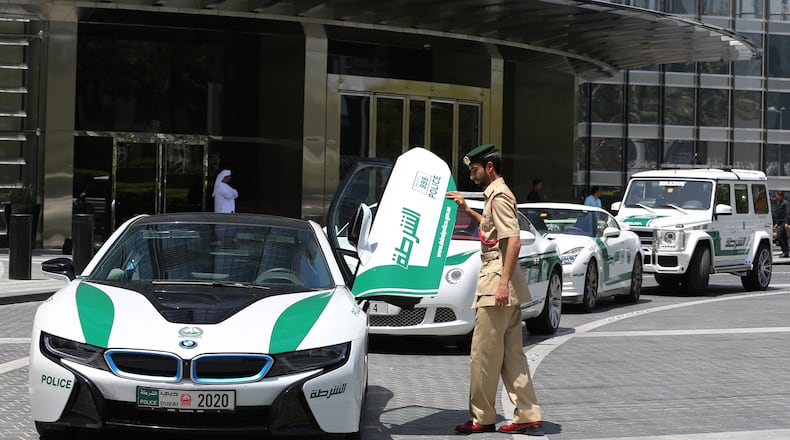 In this Thursday May 19, 2016 photo, Dubai police Lt. Saif Sultan Rashed al-Shamsi, who oversees the tourist police’s patrol section, pushes down one of the twin scissor doors of the $140,000 BMW i8 during a demonstration in Dubai, United Arab Emirate. Police in Dubai have built up a high-horsepower arsenal of luxury sports cars and SUVs over the years to complement its fleet of green-and-white patrol cruisers. They say it is a way to reach out to the community and make their officers more accessible to the public in a country home to huge foreign workforce. (AP Photo/Kamran Jebreili)