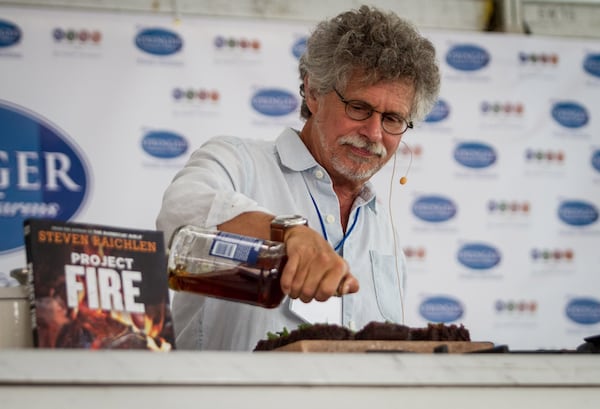 Author Steven Raichlen pours bourbon over S'mores he was cooking on a grill during the 2018 book festival. (Steve Schaefer for the AJC)