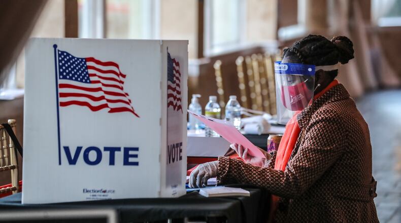 A poll worker sorts through voting material at Park Tavern in Atlanta on Election Day, Tuesday, Nov. 3, 2020. (John Spink / John.Spink@ajc.com)