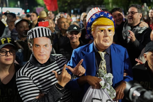 Protesters wearing masks of U.S. President Donald Trump, right, and former President of Brazil Jair Bolsonaro demonstrate after Trump's announcement of 50% tariffs on Brazilian goods, in Sao Paulo Thursday, July 10, 2025. (AP Photo/Andre Penner)
