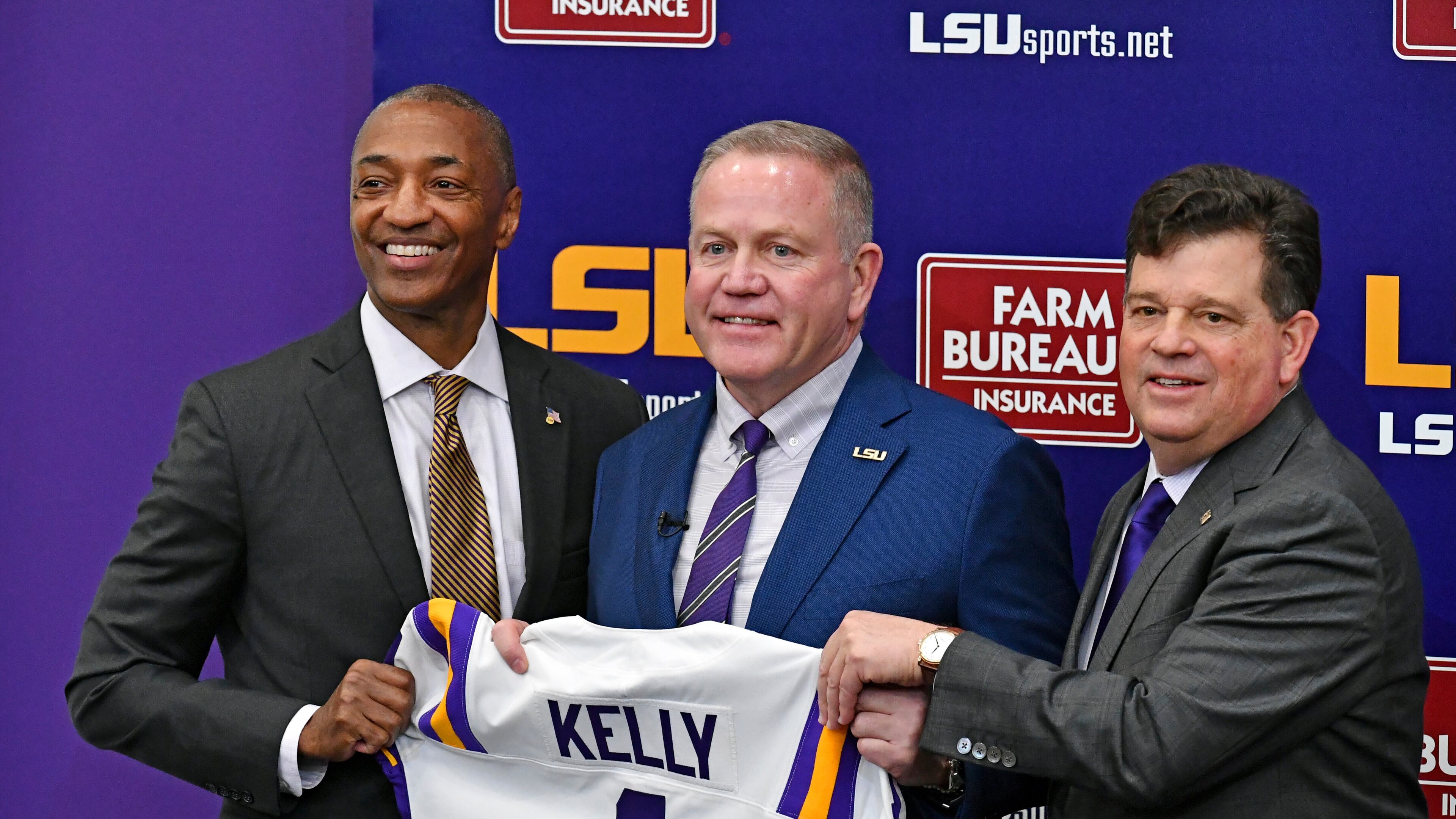 LSU head coach Brian Kelly, center, stands with school president William F. Tate IV, left, and athletic director Scott Woodward, right, as he is introduced during an NCAA college football news conference Dec. 1, 2021, in Baton Rouge, La. (Hilary Scheinuk/The Advocate via AP)