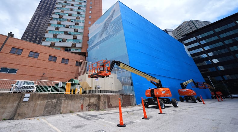 A section of a mural, known as the "Whaling Wall 82," created by artist Wyland, is visible as part of it on the right side of the building was painted over, Monday, May 18, 2026, in Dallas. (AP Photo/Julio Cortez)