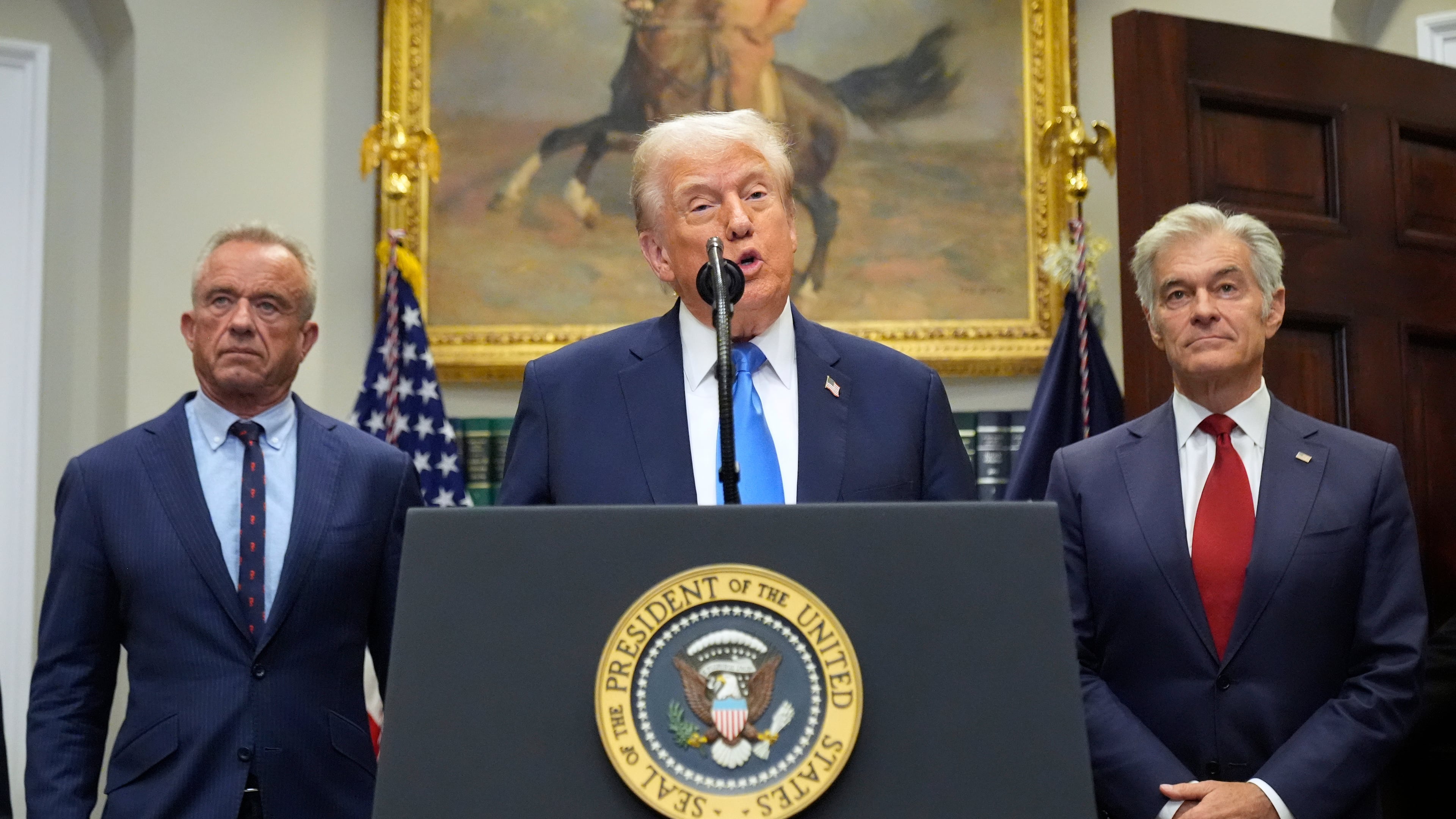 President Donald Trump speaks in the Roosevelt Room of the White House, Monday, Sept. 22, 2025, in Washington, as Health and Human Services Secretary Robert F. Kennedy Jr., left, and Centers for Medicare & Medicaid Services administrator Dr. Mehmet Oz listen. (AP Photo/Mark Schiefelbein)