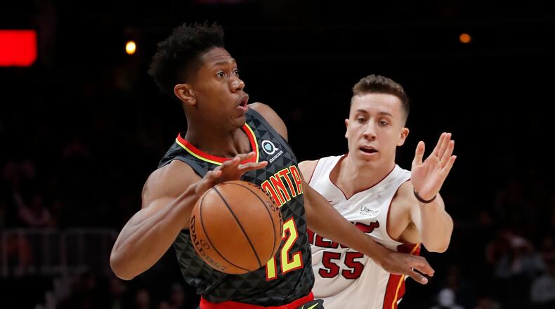 Atlanta Hawks forward De'Andre Hunter (12) works his way past Miami Heat forward Duncan Robinson (55) during the first half of an NBA basketball game Thursday, Oct. 31, 2019, in Atlanta. (AP Photo/John Bazemore)