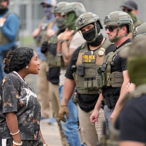 A protester talks to masked federal agents standing outside the Delaney Hall detention center during a protest against the transfer of detainees on Wednesday, May 27, 2026, in Newark, N.J. (AP Photo/Seth Wenig)