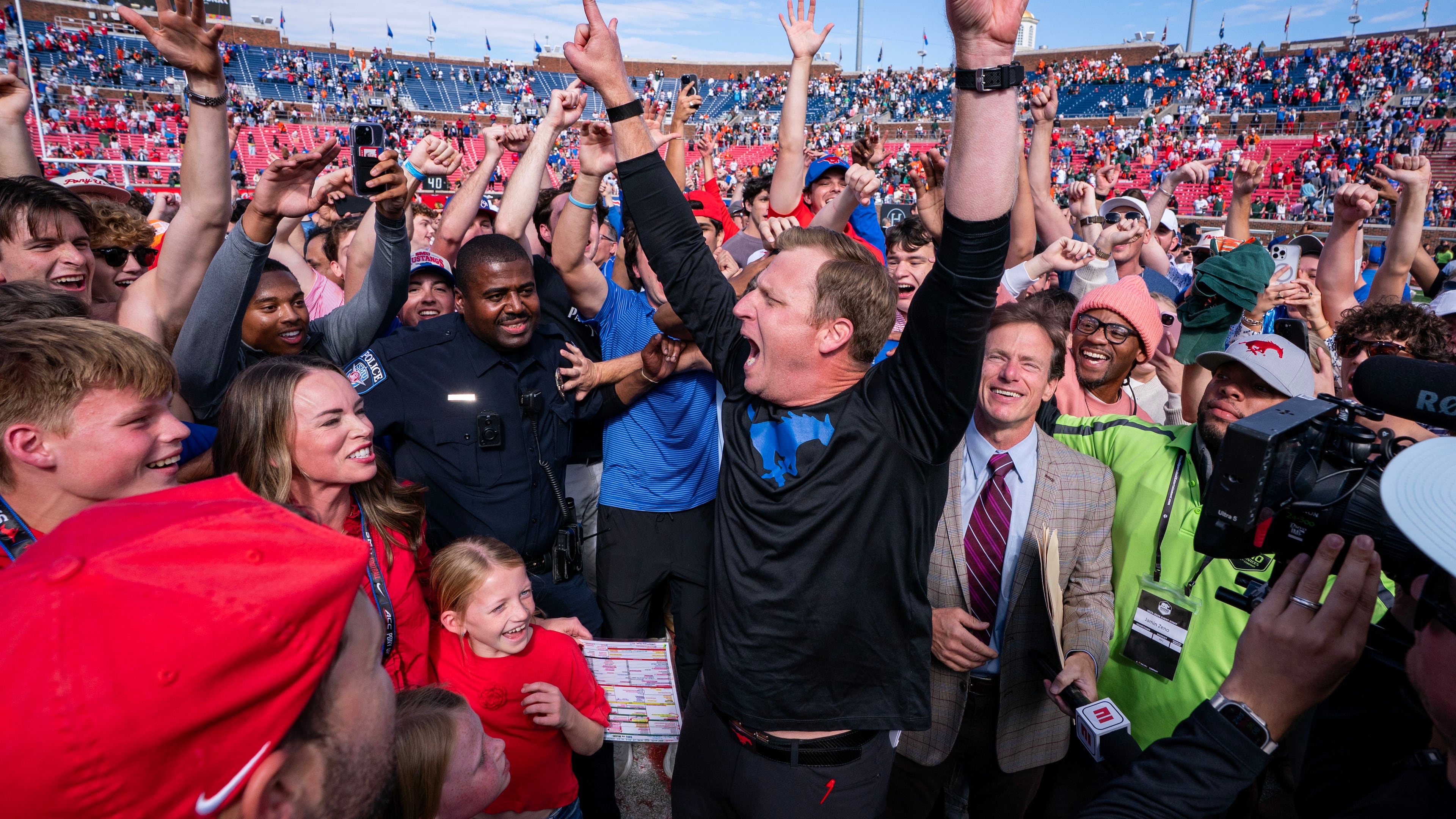 SMU head coach Rhett Lashlee celebrates on the field with fans after his team's 26-20 overtime win over Miami in an NCAA college football game, Saturday, Nov. 1, 2025, in Dallas. (AP Photo/Jeffrey McWhorter)