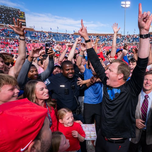 SMU head coach Rhett Lashlee celebrates on the field with fans after his team's 26-20 overtime win over Miami in an NCAA college football game, Saturday, Nov. 1, 2025, in Dallas. (AP Photo/Jeffrey McWhorter)