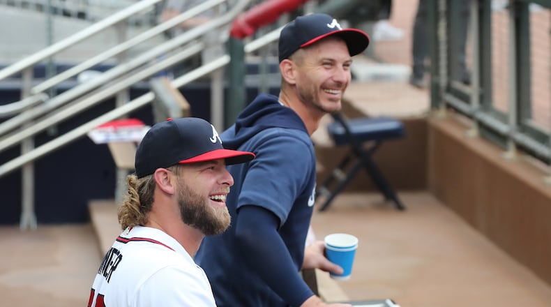 Atlanta Braves pitcher A.J. Minter is all smiles after rejoining the team in the dugout before playing the Cincinnati Reds in a MLB baseball game on Wednesday, August 11, 2021, in Atlanta. “Curtis Compton / Curtis.Compton@ajc.com”