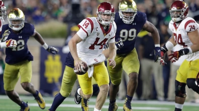 FILE - In this Oct. 21, 2017, file photo, Southern California quarterback Sam Darnold scrambles during the second half of an NCAA college football game against Notre Dame in South Bend, Ind. Darnold, a third-year sophomore, hasn't said yet if he will return to eight-ranked USC for another season or if the Cotton Bowl against fifth-ranked Ohio State will be his Trojans finale. He has to decide by Jan. 15 whether to make himself eligible for the next NFL draft, which will be held in late April in the same stadium where he will play Friday night. (AP Photo/Carlos Osorio, File)