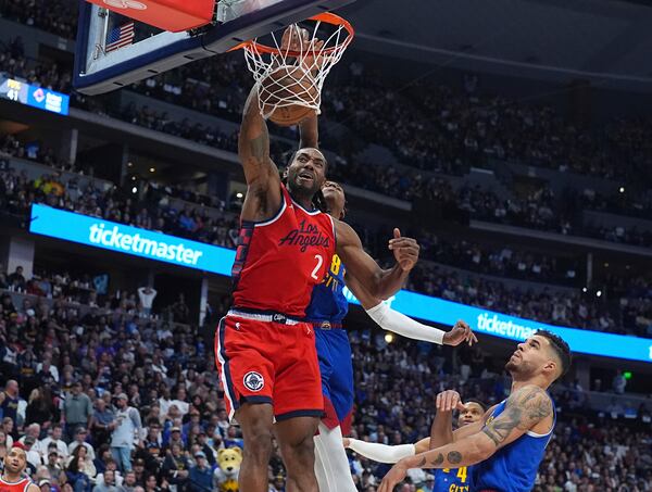 Los Angeles Clippers forward Kawhi Leonard, front left, dunks while Denver Nuggets forwards Peyton Watson, back left, and Michael Porter Jr. defend in the second half of Game 1 of an NBA first-round playoff series Saturday, April 19, 2025, in Denver. (AP Photo/David Zalubowski)