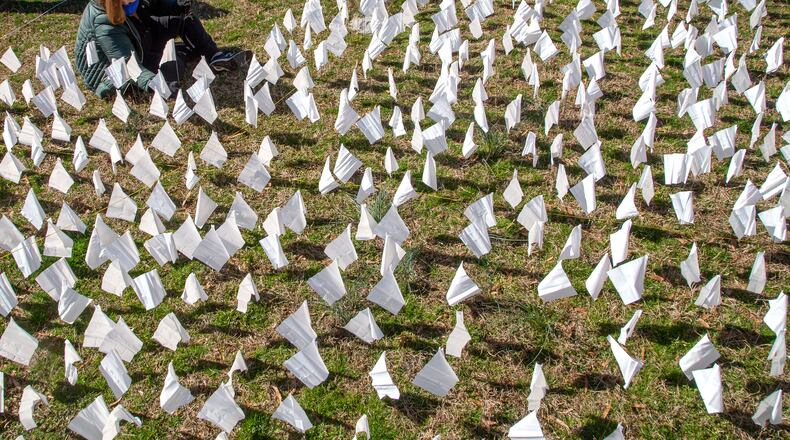 In February, volunteers planted flags on the lawn of First Christian Church of Decatur, representing the number of COVID-19 deaths in Georgia — 15,000 at the time. On Thursday, Georgia reported a total number of 25,042 confirmed deaths due to COVID-19, the first time that the state had topped 25,000. (Steve Schaefer for The Atlanta Journal-Constitution)