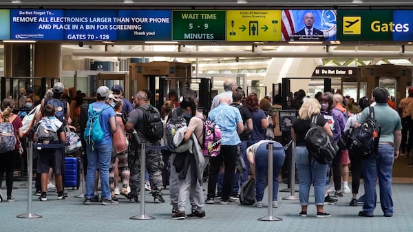 FILE - Travelers line up to go through a TSA checkpoint at Orlando International Airport before the Memorial Day weekend, May 28, 2021, in Orlando, Fla. (AP Photo/John Raoux, File)