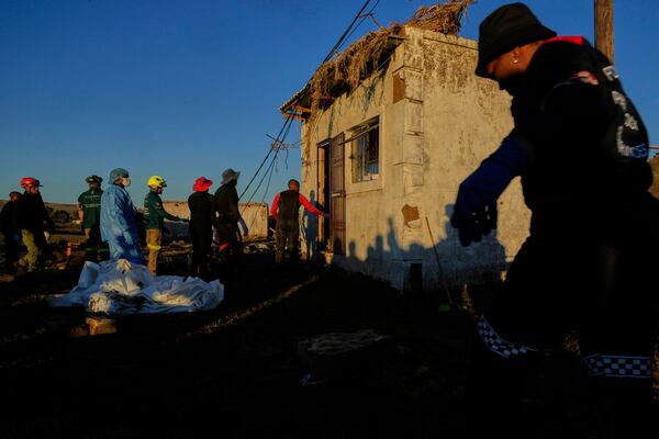 Forensic workers retrieve bodies of a mother and three daughters inside a one room house after floods swept through the area in Mthatha, South Africa, Thursday, June 12, 2025. (AP Photo/Themba Hadebe)