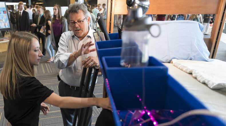 Elizabeth Johnson, a senior biomedical engineering student at Georgia Tech, left, speaks with Darrell Moyer, with Southwest Contract, the company that designs and manufactures the beds used in college dorms. (DAVID BARNES / DAVID.BARNES@AJC.COM)