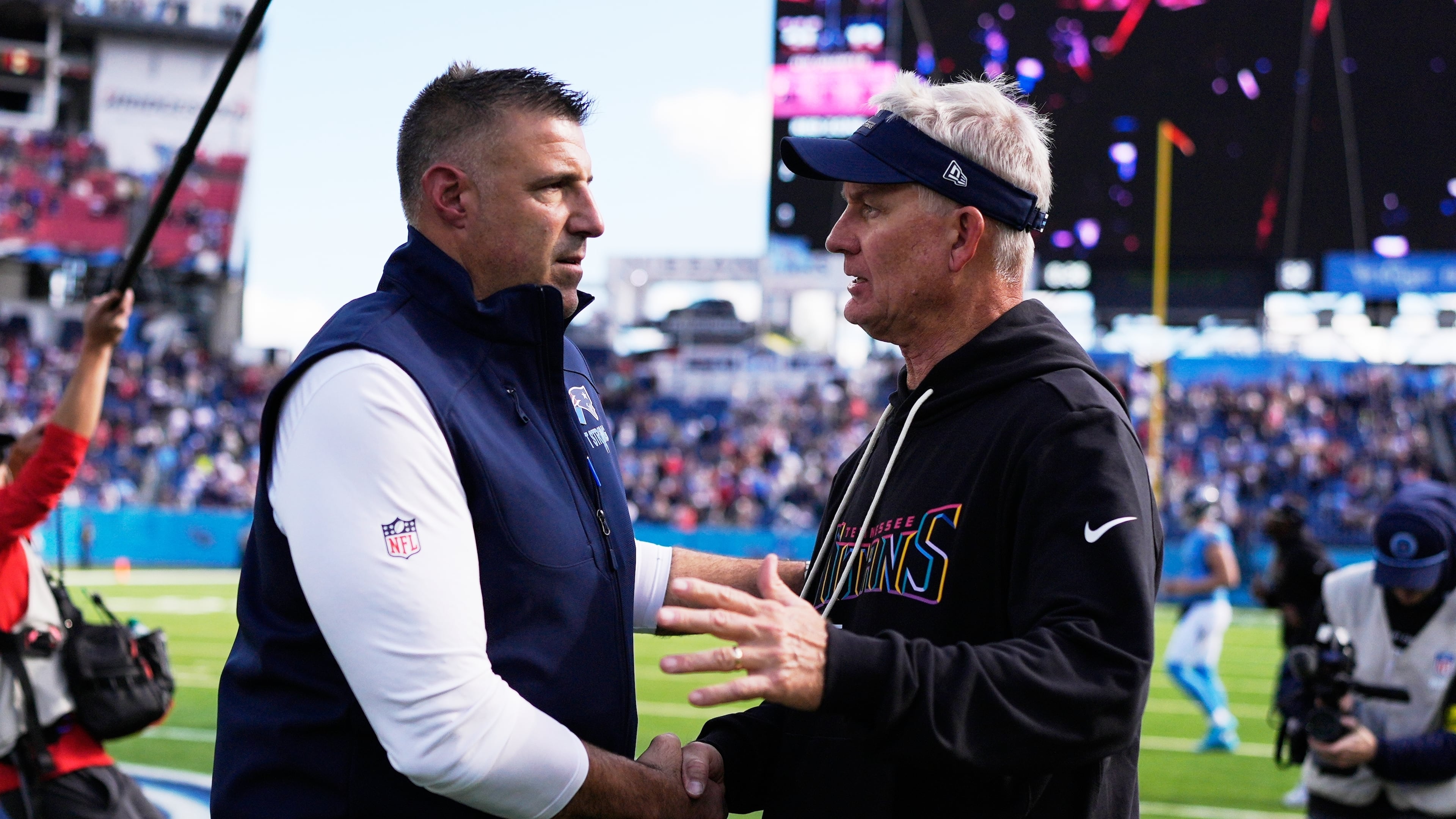 New England Patriots head coach Mike Vrabel, left, shakes hands with Tennessee Titans interim head coach Mike McCoy following an NFL football game, Sunday, Oct. 19, 2025, in Nashville, Tenn. (AP Photo/George Walker IV)