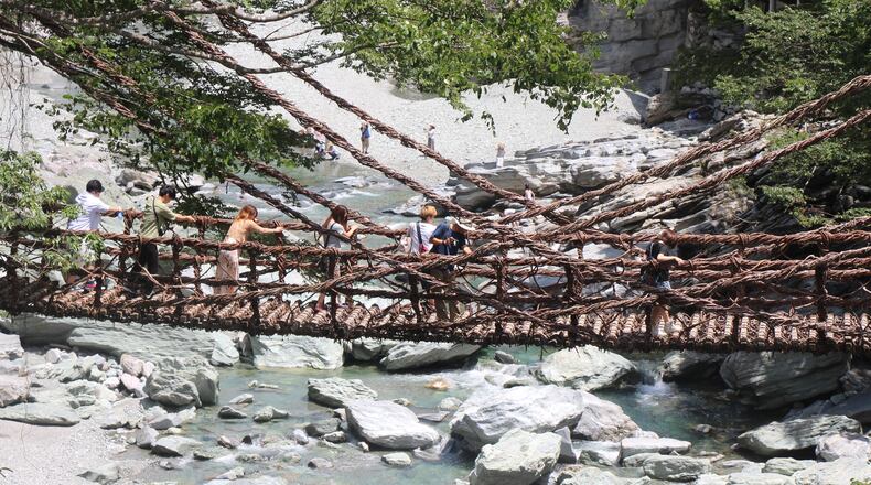 Visitors gingerly cross a traditional (but steel-reinforced) vine bridge. Photo by Mark Jenkins for The Washington Post.