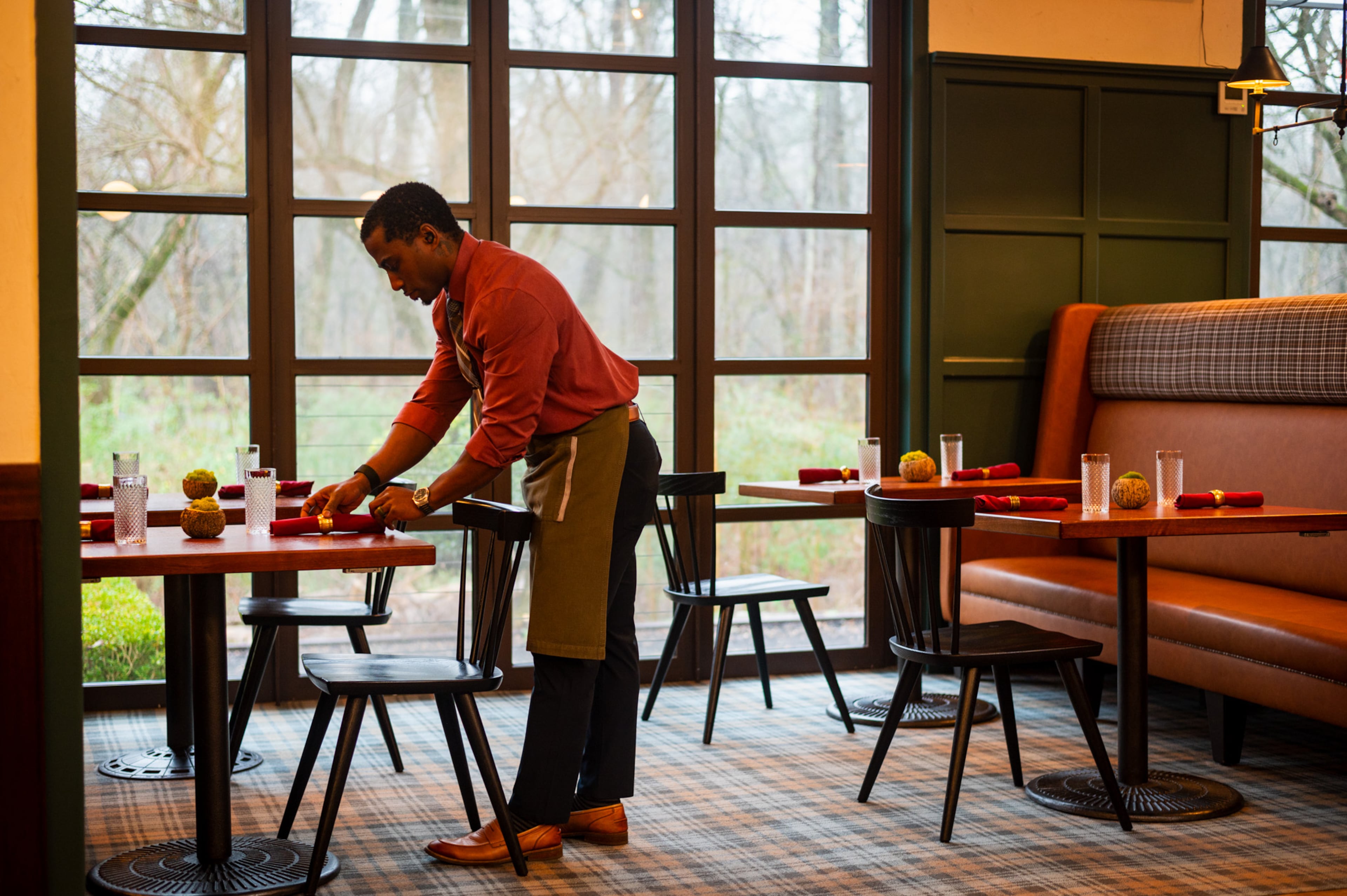 Rell Hall sets up the dining room at Nàdair. (Henri Hollis/AJC)