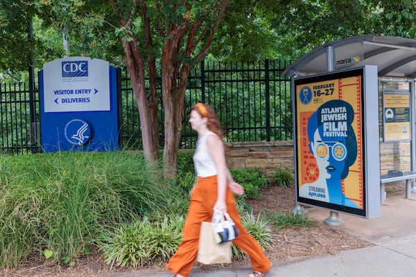 A person walks in front of the CDC entrance on Clifton Road, Which is near a MARTA stop, in Atlanta on Tuesday, August 2, 2022. (Arvin Temkar / arvin.temkar@ajc.com)