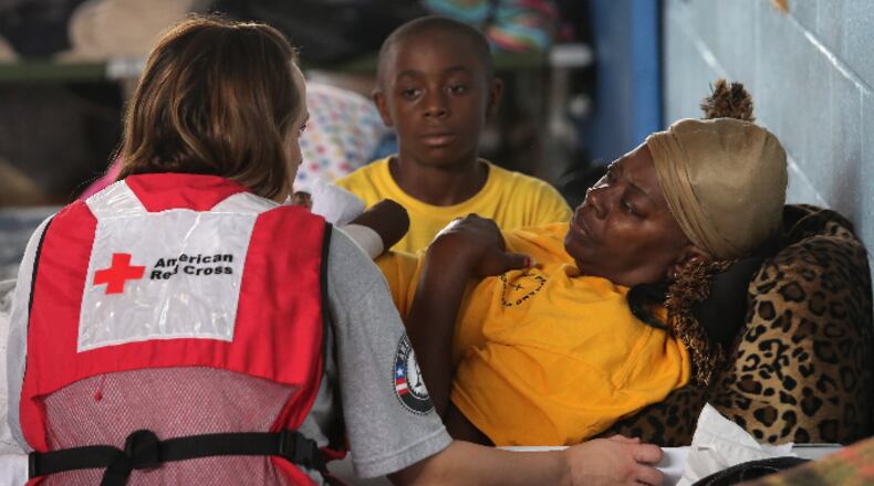 KENTWOOD, LA - AUGUST 30: A Red Cross worker speaks with flood evacuee Deborah Watson, 55, at a flood shelter set up in a high school gym on August 30, 2012 in Kentwood, Louisiana. Local residents evacuated to the shelter after officials announced that a dam upstream in Mississippi was in danger of bursting due to rains from Hurricane Isaac. Tens of thousands of people were asked to evacuate the area due to the high flood risk. (Photo by John Moore/Getty Images)
