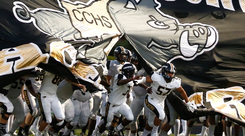 Colquitt County players break through their banner at the start of a high school football game Sept. 21, 2018, at Grayson High School.