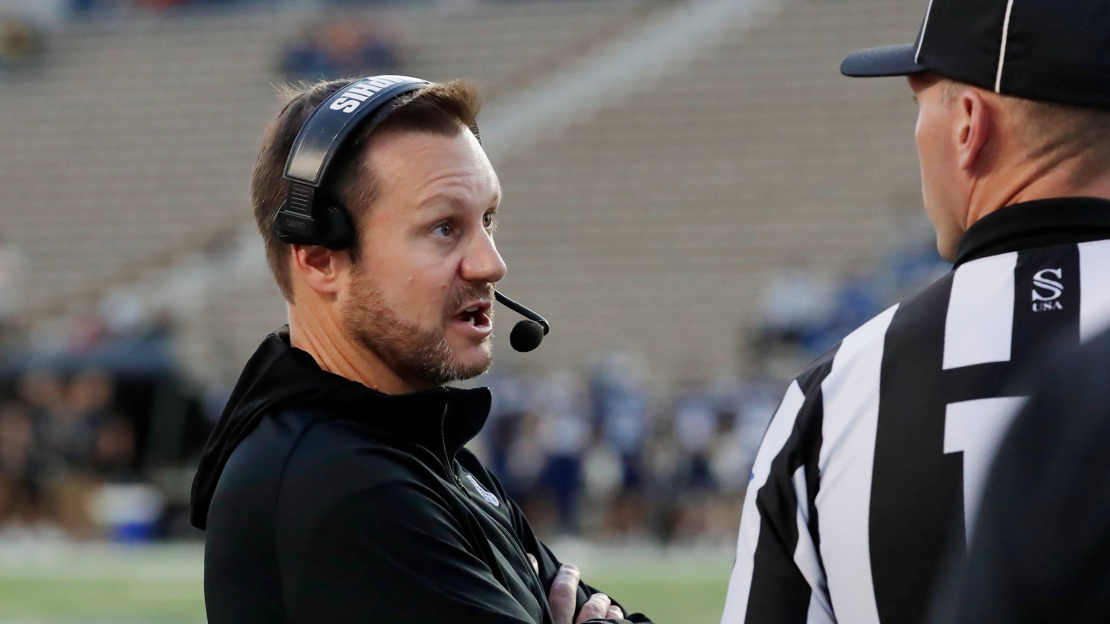 Memphis head coach Ryan Silverfield, left, talks with an official after a penalty during the first half of an NCAA college football game against Rice, Friday, Oct. 31, 2025, in Houston. (AP Photo/Michael Wyke)