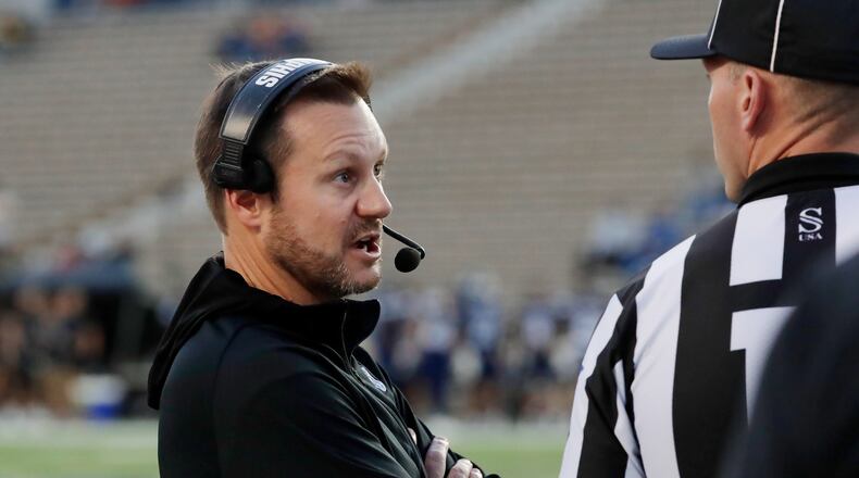 Memphis head coach Ryan Silverfield, left, talks with an official after a penalty during the first half of an NCAA college football game against Rice, Friday, Oct. 31, 2025, in Houston. (AP Photo/Michael Wyke)