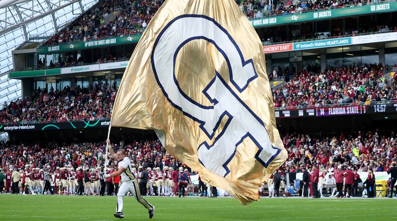 A Georgia Tech cheerleader runs the school flag during the NCAA college football game between Georgia Tech and Florida State at the Aviva stadium in Dublin, Saturday, Aug. 24, 2024. (AP Photo/Peter Morrison)
