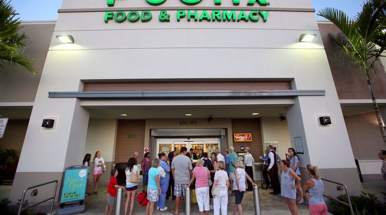 A small crowd gathers outside the new Boynton Beach Publix in Sunshine Square before its grand opening. (Lannis Waters/ The Palm Beach Post)