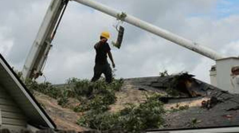 A member of a tree service company removes a tree from the roof of a damaged home in Valdosta during cleanup after Tropical Storm Hermine on Friday, Sept. 2, 2016. CURTIS COMPTON /ccompton@ajc.com