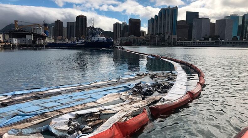 In this photo provided by the U.S. Coast Guard, their crews and other local agencies respond Thursday to an oil spill from vessel Kamokuiki at Pier 19 in Honolulu. Two response vessels arrived on scene and deployed 1,600 feet of hard boom surrounding 25 bales of absorbent material.