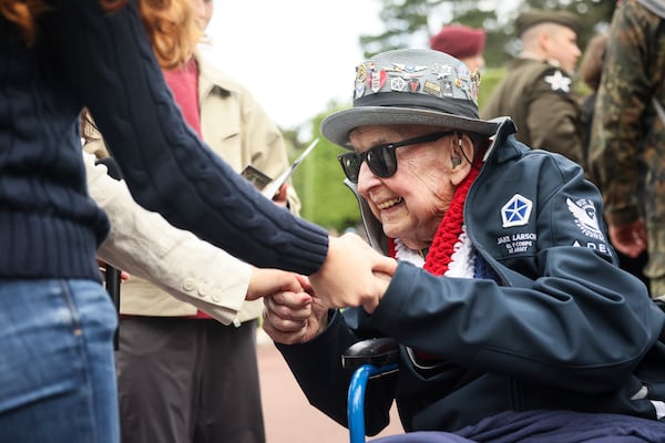 World War II veteran Jake Larson meets youths during ceremonies at the US cemetery to commemorate the 81st anniversary of the D-Day landings, Friday, June 6, 2025 in Colleville-sur-Mer, Normandy. (AP Photo/Thomas Padilla)