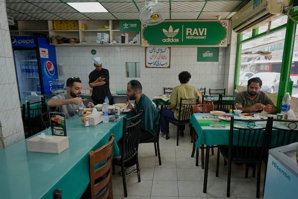 People dine at Ravi restaurant in Satwa district of Dubai, United Arab Emirates, Monday, June 9, 2025. (AP Photo/Altaf Qadri)