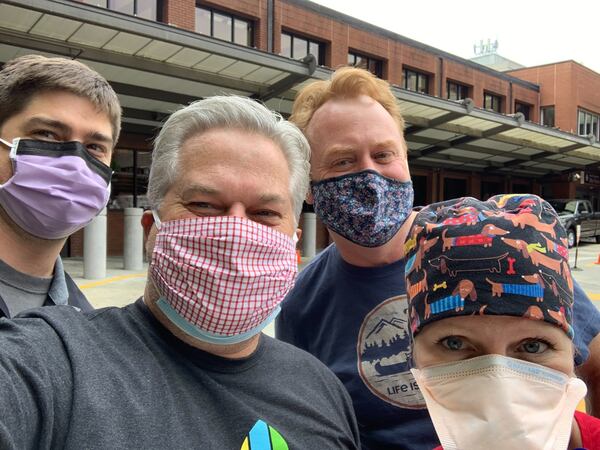 Flanked by doctors at Piedmont Hospital, Hal Boyd and Doug Brandberg deliver barbecue sandwiches. Brandberg said BBQ Love was something he looked forward to doing during the pandemic. Courtesy of Hal Boyd