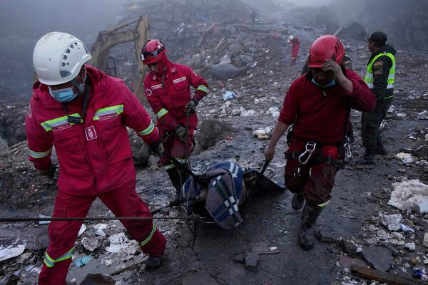 Firefighters carry a body of a victim of an explosive attack near the Hijos de Ingenio gold mine in Yani, Bolivia, Thursday, April 3, 2025. (AP Photo/Juan Karita)