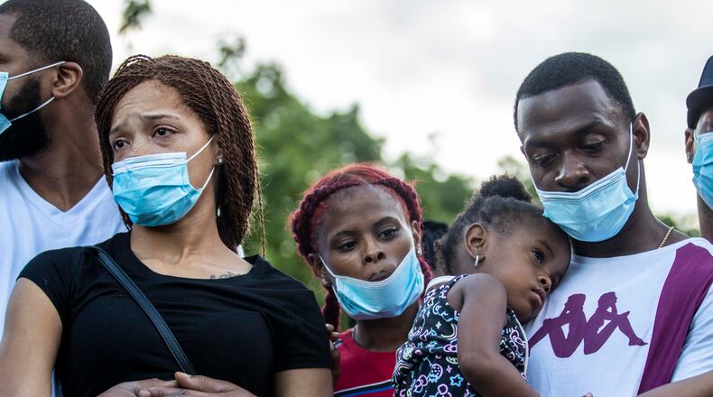 07/07/2020 - Atlanta, Georgia - Charmaine Turner (second from left) and Secoriey Williamson (right) are emotional as people pray for them during a vigil for their daughter, Secoriea Turner, at Ralph David Palza in Atlanta's Mechancsville community, Tuesday, July 7, 2020. There is a $20,000 reward for information leading to identifying and finding four men that APD believes are people of interest in the killing of 8-year-old Secoriea Turner. Secoriea was shot and killed while riding with her family along University Avenue, near the Wendy's where Rayshard Brooks was shot and killed by an APD officer.(ALYSSA POINTER / ALYSSA.POINTER@AJC.COM)