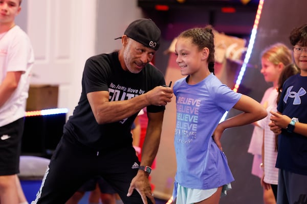 Glenn Davis encourages Eva Teden, 8, as she gets ready to work on a drill in July at the Rig Gym in Hoschton, where many hope to compete on day on "American Ninja Warrior." (Miguel Martinez/AJC)