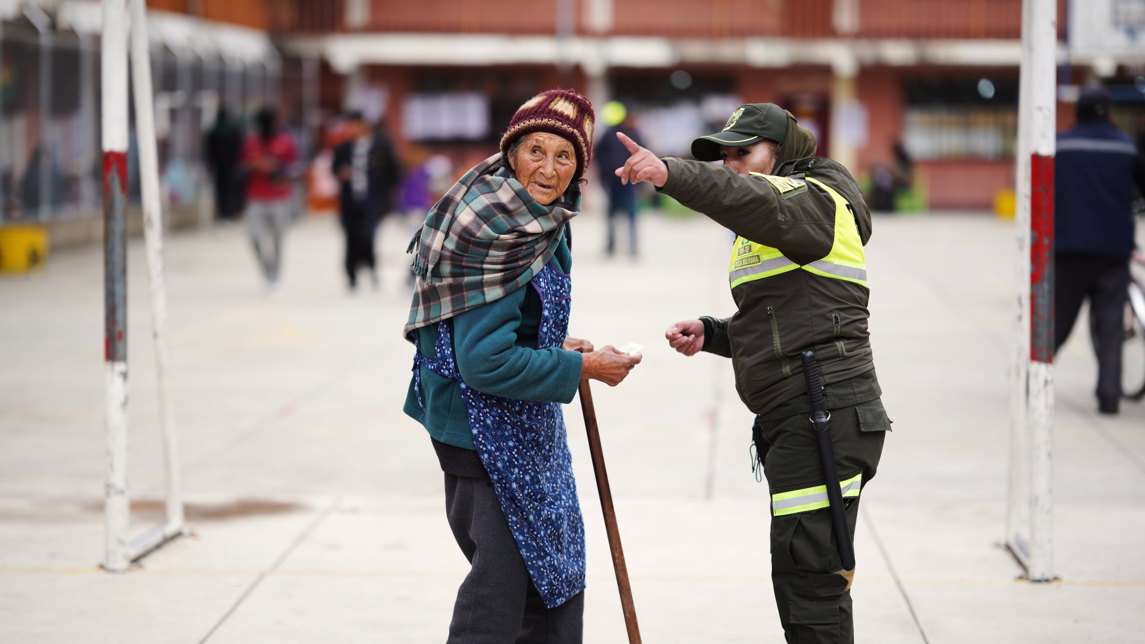 A police officer points the way to a polling station for a voter during a presidential runoff election in El Alto, Bolivia, Sunday, Oct. 19, 2025. (AP Photo/Ivan Valencia)