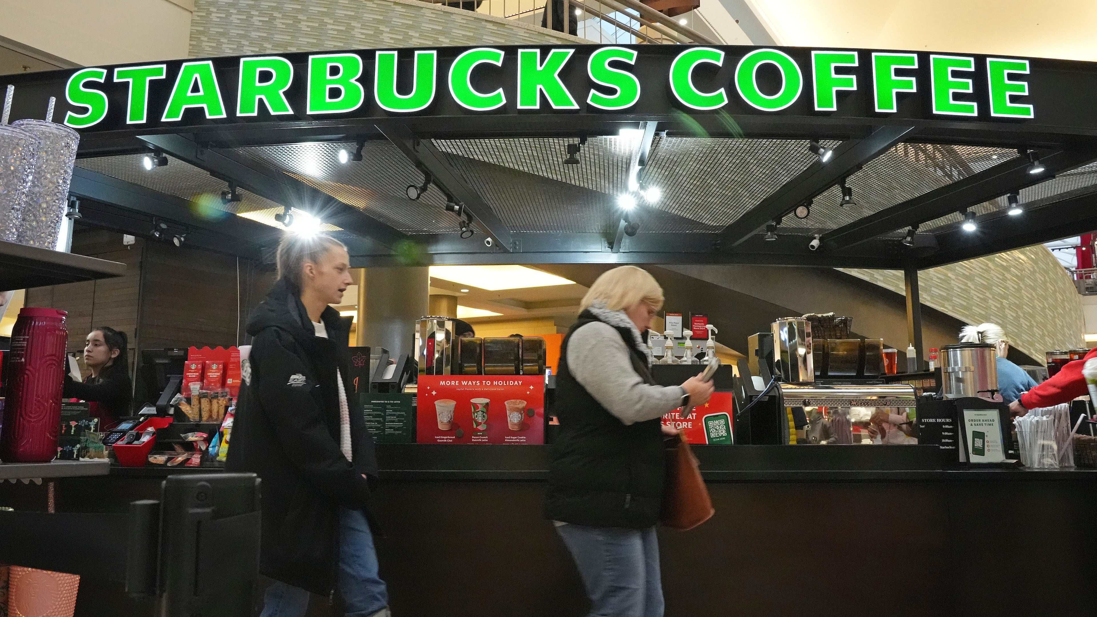 FILE - Shoppers at the Walden Galleria in Buffalo, NY, stop by the Starbucks kiosk on Saturday, Nov. 30, 2024. (AP Photo/Gene J. Puskar, File)