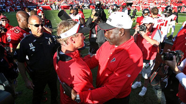 Falcons interim coach Emmitt Thomas and Buccaneers coach Jon Gruden meet on the field after the Bucs defeated the Falcons 37-3.