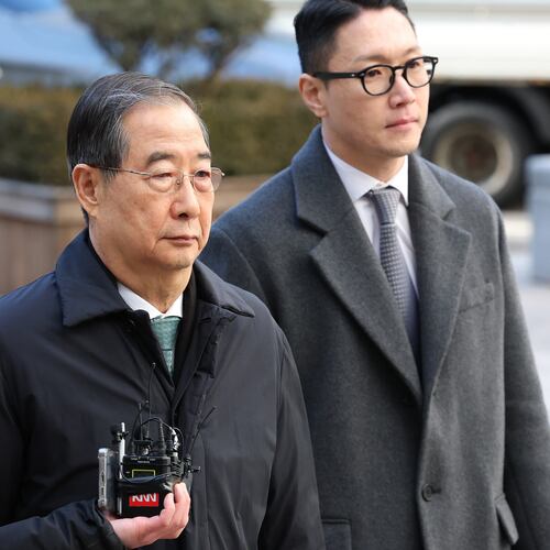 Former South Korean Prime Minister Han Duck-soo, center, arrives at the Seoul Central District Court for his first sentencing trial in the insurrection case, in Seoul Wednesday, Jan. 21, 2026. (Chung Sung-Jun/Pool Photo via AP)