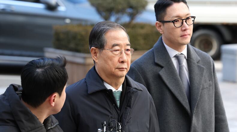 Former South Korean Prime Minister Han Duck-soo, center, arrives at the Seoul Central District Court for his first sentencing trial in the insurrection case, in Seoul Wednesday, Jan. 21, 2026. (Chung Sung-Jun/Pool Photo via AP)